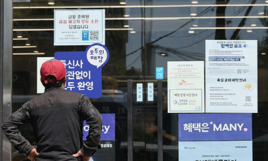 2일 서울 시내의 한 SK텔레콤 대리점 앞에서 한 소비자가 유심 재고 소진 및 유심보호서비스 관련 안내문을 살펴보고 있다. 연합뉴스